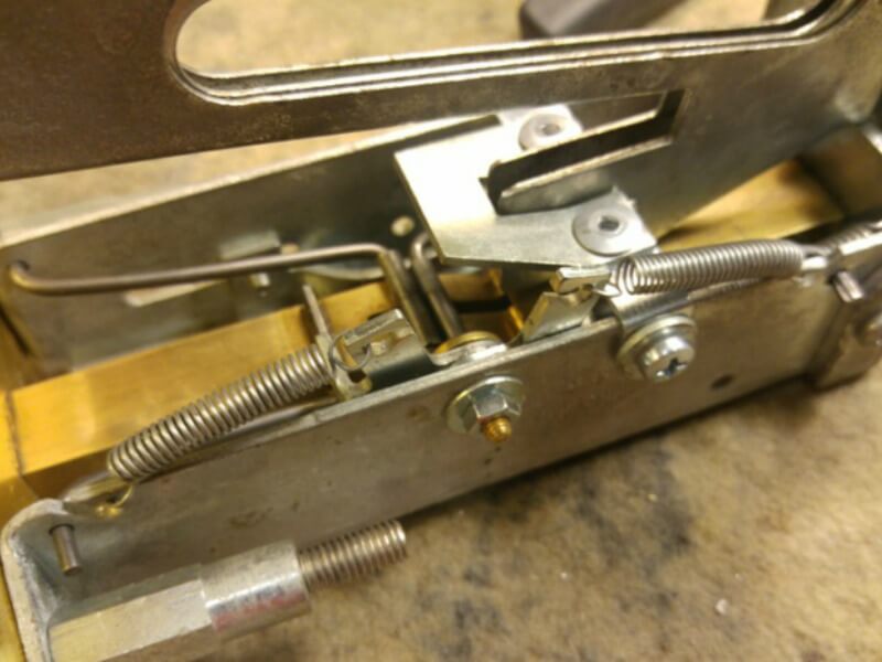 Az érme kidobó és kihúzás akadályozására szolgáló karokhoz a lenyomó fülek rögzítése és a rugók felhelyezése. Az érme kidobó és kihúzás akadályozására szolgáló karokhoz a lenyomó fülek rögzítése és a rugók felhelyezése.